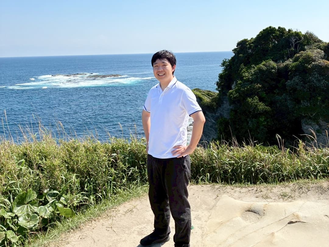 写真：海を望む岬に立つ近藤さん