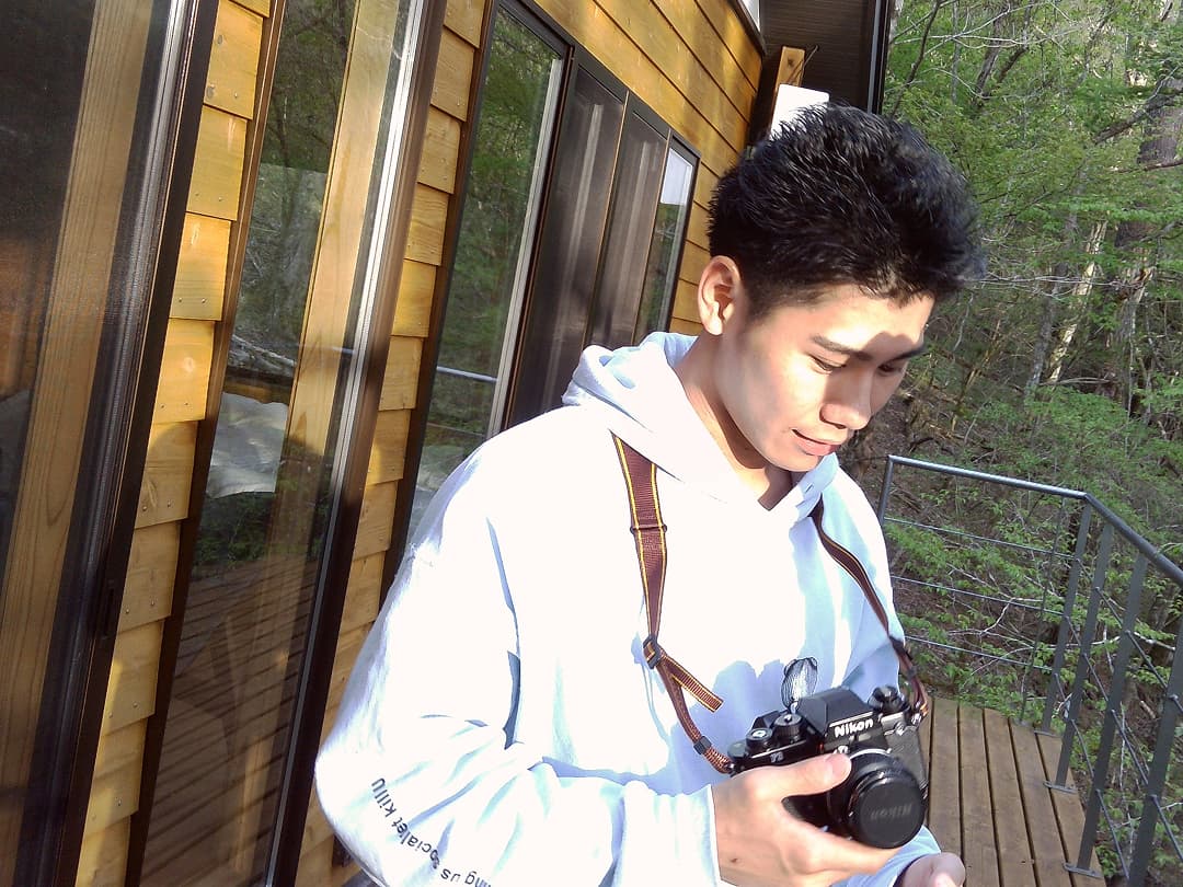 写真：フィルムカメラを手にする小島さん